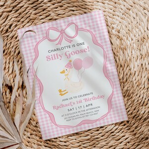 May include: Pink and white gingham patterned invitation with a white border and a pink bow. The invitation says "Charlotte is one Silly Goose!" and includes details for a birthday party.