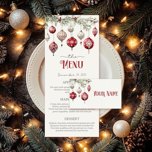 Puede incluir: Un menú y una tarjeta de mesa con temática navideña, con adornos rojos y blancos, ramas de pino y luces de cadena. El menú dice "the MENU" y "December 14, 2025". La tarjeta de mesa dice "YOUR NAME".