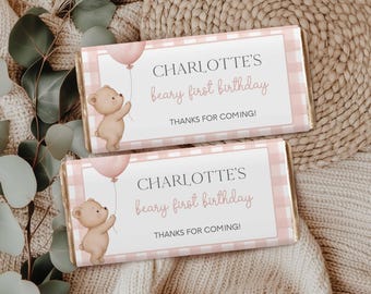 May include: Two chocolate bar wrappers with a pink gingham pattern and the text "CHARLOTTE'S beary first birthday". Each wrapper features a watercolor illustration of a teddy bear holding a pink balloon. The text "THANKS FOR COMING!" is also included.