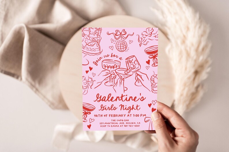 May include: Pink invitation card with red text and illustrations. The text reads "Join us for a Galentine's Girls Night 14th of February at 1:00 PM The Caps Bar 151 Mintreal Ave, Regina, CA RSVP to Emma at 437-123-4567".