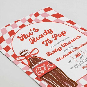 May include: Baby shower invitation with a retro design. The invitation features a red and pink checkered pattern and a cartoon cola bottle illustration. Text includes "She's Ready To Pop" and event details.