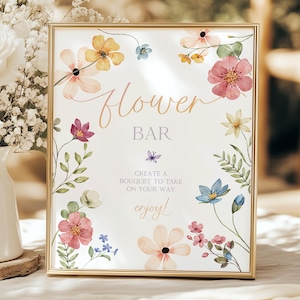 May include: A printable sign with a floral design and the text "Flower Bar" in a gold frame. The sign also includes the text "Create a bouquet to take on your way enjoy!"