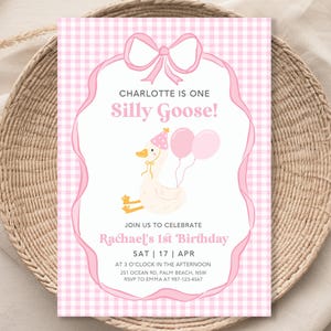 May include: Pink and white gingham patterned invitation with a pink bow at the top. The invitation says "Charlotte is one Silly Goose!" and includes a cartoon goose with a party hat and balloons. The invitation also includes the text "Join us to celebrate Rachael's 1st Birthday" and details for the party.