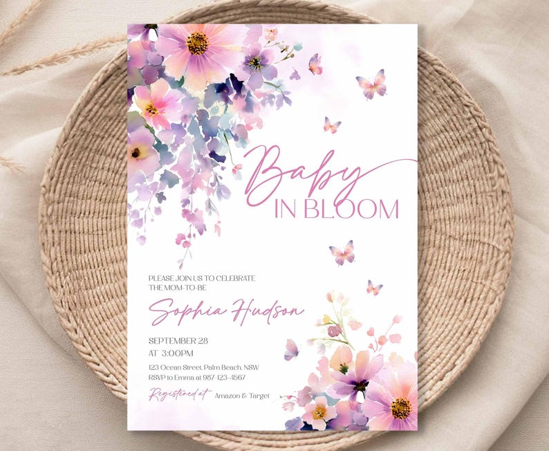 Może przedstawiać: Zaproszenie na baby shower ze słowami "Baby in Bloom" w r&oacute;żowym skrypcie. Zaproszenie zawiera akwarelowe ilustracje kwiat&oacute;w i motyli w odcieniach r&oacute;żu i fioletu. Szczeg&oacute;ły obejmują imię przyszłej mamy, datę, godzinę i miejsce.