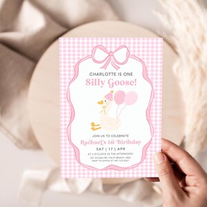 May include: Pink and white gingham patterned invitation with a pink bow and a cartoon goose wearing a pink party hat. The text reads "Charlotte is one Silly Goose!" and "Join us to celebrate Rachael's 1st Birthday Sat | 17 | Apr at 2 o'clock in the afternoon 31 Ocean Rd, Palm Beach, NSW RSVP to Emma at 123 456"