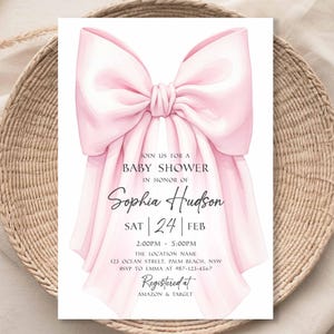 Op de afbeelding: Een uitnodiging voor een babyshower met een grote, lichtroze strik bovenaan. De uitnodiging bevat de tekst "Doe met ons mee voor een babyshower ter ere van Sophia Hudson" en evenementdetails. De uitnodiging staat op een neutrale achtergrond.