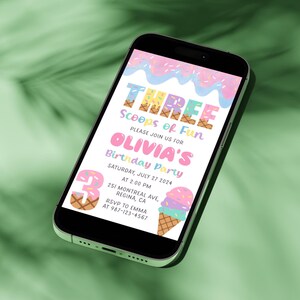 May include: A smartphone displays a colorful birthday party invitation. The invitation reads "THREE Scoops of Fun" and includes details for Olivia's party on July 27, 2024, at 2:00 PM. The design features ice cream cones and sprinkles.