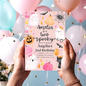May include: A pink invitation card for Amelia's second birthday, featuring ghosts, pumpkins, bats, and the text "Amelia is a two spooky". The card includes event details and RSVP information.