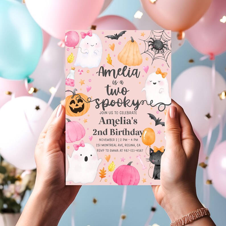 May include: A pink invitation card for Amelia's second birthday, featuring ghosts, pumpkins, bats, and the text "Amelia is a two spooky". The card includes event details and RSVP information.