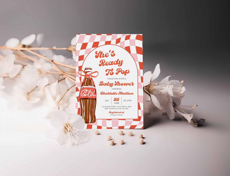 May include: Baby shower invitation with a retro design. The invitation features a Coca-Cola bottle illustration and the text "She's Ready To Pop." The background has a red and pink checkered pattern. The invitation includes the honoree's name, date, and time.