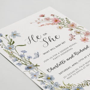 May include: A gender reveal party invitation with a floral border. The invitation features blue and pink flowers and butterflies. The text reads "He or She? What will baby be? Join us for a gender reveal party honoring Charlotte and Richard. Saturday, April 17th at 2 PM. 251 Ocean Rd, Palm Beach, NSW. RSVP to Emma at 987-123-4567."
