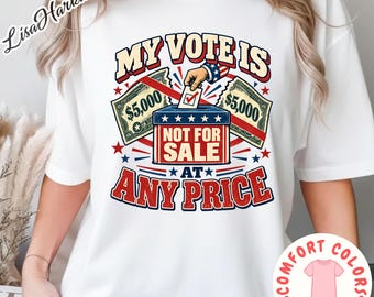 Puede incluir: Una camiseta blanca de manga corta con un gráfico que incluye el texto 'MY VOTE IS NOT FOR SALE AT ANY PRICE'. El diseño muestra una urna, una mano insertando una papeleta y dos billetes de 5.000 dólares en rojo, blanco y azul con estrellas.
