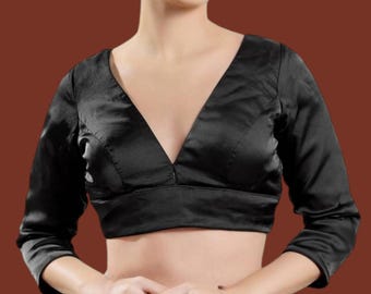 Könnte beinhalten: Eine schwarze Satinbluse mit tiefem V-Ausschnitt und Dreiviertelärmeln.