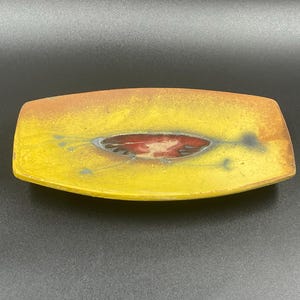May include: A yellow ceramic rectangular dish with a red and black design in the centre.