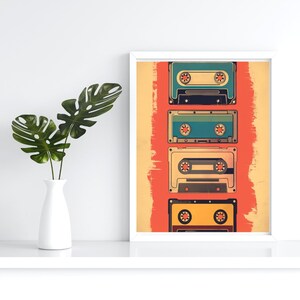 Op de afbeelding: Een ingelijst print met een vintage esthetiek met vijf cassettebandjes die verticaal op een rode achtergrond zijn gestapeld. De bandjes zijn in verschillende kleuren, waaronder blauw, groen, geel en zwart.