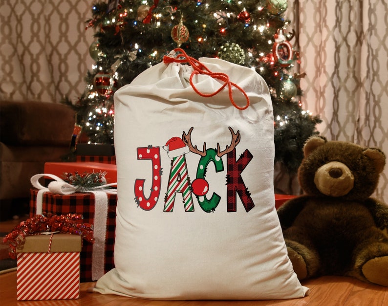 a teddy bear sitting next to a christmas sack