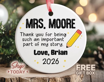 May include: A round white ceramic ornament hanging from a red ribbon. The text reads: MRS. MOORE, Thank you for being such an important part of my story., Love, Brian, 2026. A yellow pencil graphic and small yellow stars are printed on the surface.