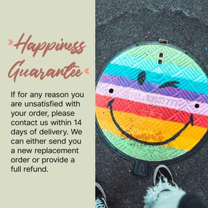 a colorful, multicolored manhole cover with a smiley face drawn on it. The manhole cover is placed on a street, and there is a person's feet visible in the bottom right corner of the image.