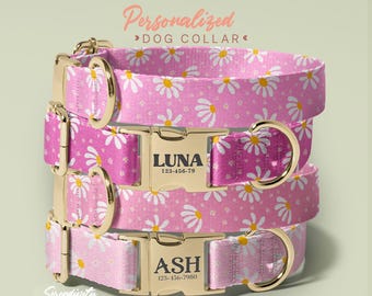 May include: Three personalized dog collars stacked on top of each other. The collars are pink with a white daisy pattern. Each collar has a gold-colored buckle with a name and phone number. The text "Personalized Dog Collar" is at the top.
