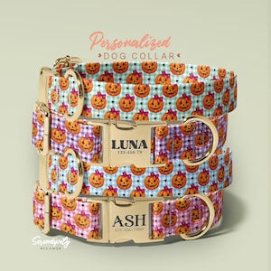 May include: A stack of four dog collars featuring a repeating pattern of orange jack-o'-lanterns with pink bows on gingham backgrounds. Each collar has gold-toned metal hardware, including a side-release buckle engraved with names LUNA or ASH.