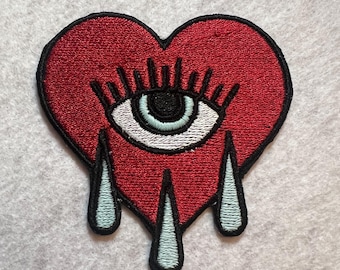 Een huilend hart in tattoo-stijl. Tranen die oplichten in het donker.