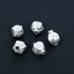 May include: Five silver pomegranate-shaped charms with a detailed design. The charms are small and have a shiny finish.