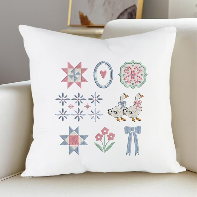 May include: White decorative pillow with embroidered designs. Features include geometric shapes, floral patterns, and two geese with bows. The color palette includes pink, blue, and green accents, creating a charming, country-inspired aesthetic.