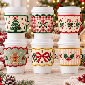 May include: Six white disposable coffee cups featuring fabric sleeves with holiday designs including a Christmas tree, a red gingham bow, candy canes, a gingerbread man, a red ribbon, and holly berries, each secured with a small wooden button.