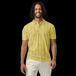 May include: A short-sleeved polo shirt in a muted yellow hue featuring a repeating vertical chevron pattern in a darker shade. The garment includes a classic collar, a three-button placket, and hemmed sleeves, presented against a solid black background.
