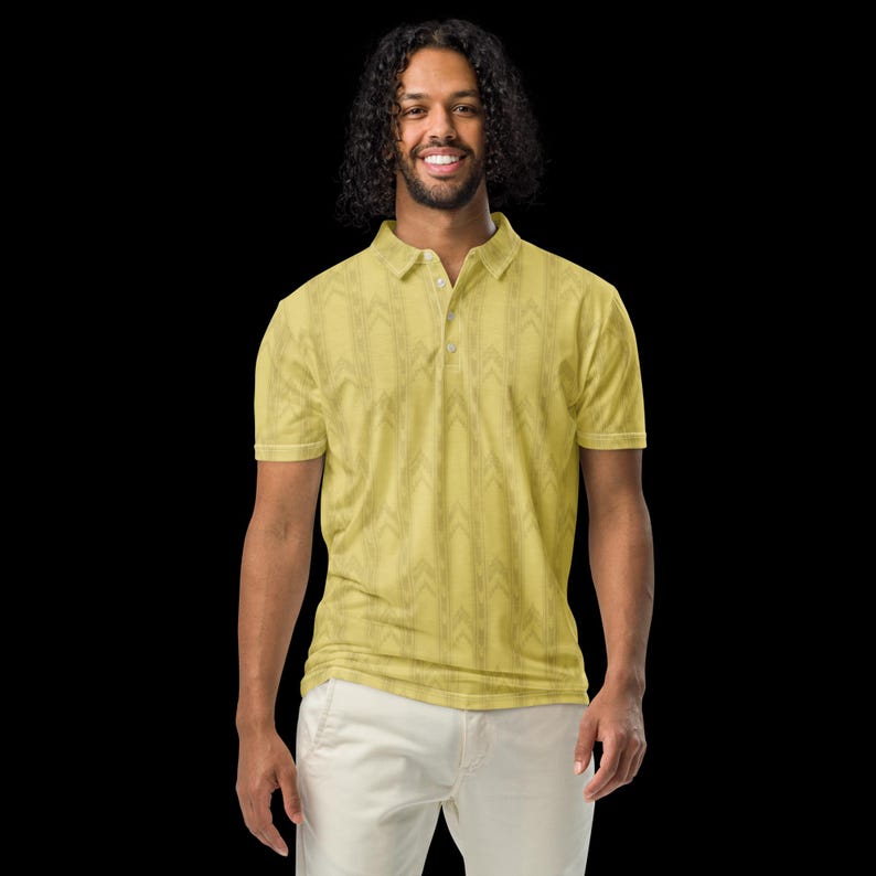May include: A short-sleeved polo shirt in a muted yellow hue featuring a repeating vertical chevron pattern in a darker shade. The garment includes a classic collar, a three-button placket, and hemmed sleeves, presented against a solid black background.