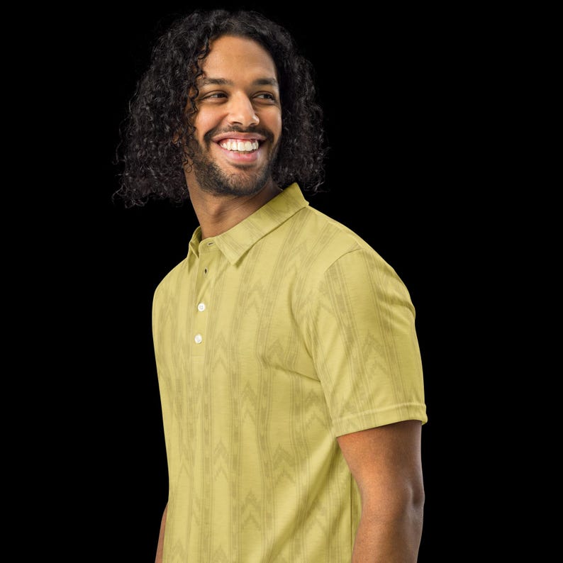 May include: A light yellow polo shirt featuring a subtle, repeating vertical chevron pattern in a slightly darker shade. The shirt has a classic collar, short sleeves, and a front placket with three white buttons visible along the center chest area.