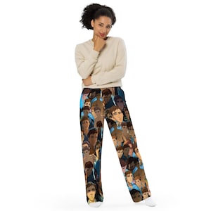 May include: Pajama trousers featuring a repeating pattern of illustrated faces in shades of brown, blue, and tan. The trousers are worn by a person in a cream-coloured long-sleeved top.