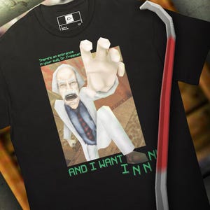 Puede incluir: Camiseta negra con una imagen de dibujos animados de un hombre extendiendo la mano, con el texto "There's an entrance in your sub, Dr. Freeman" y "AND I WANT INN". Una palanca roja y plateada es visible en el lado derecho.