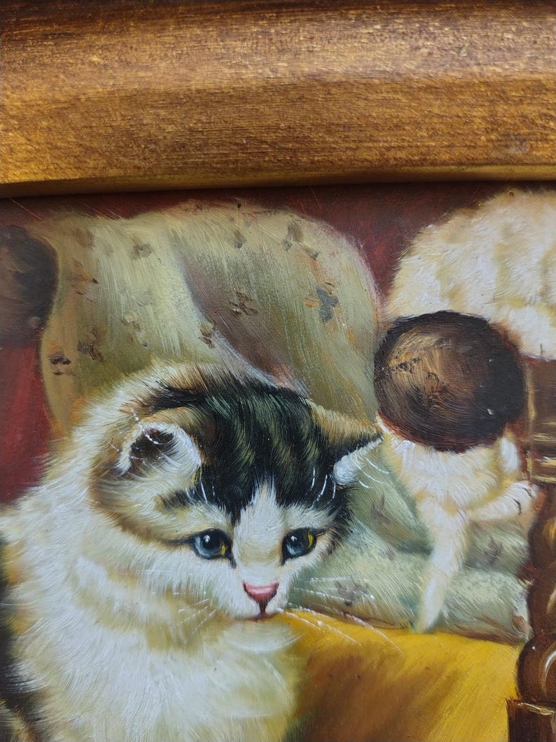 May include: A painting of two white and gray kittens sitting on a yellow chair. The kitten in the foreground is looking down with blue eyes. The background is a dark red color.