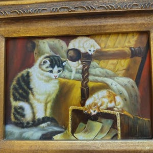 May include: A painting of three cats in a room. The largest cat is sitting on a chair with a yellow cushion. A smaller white cat is climbing on the back of the chair. The smallest cat is orange and white and is looking into a box.