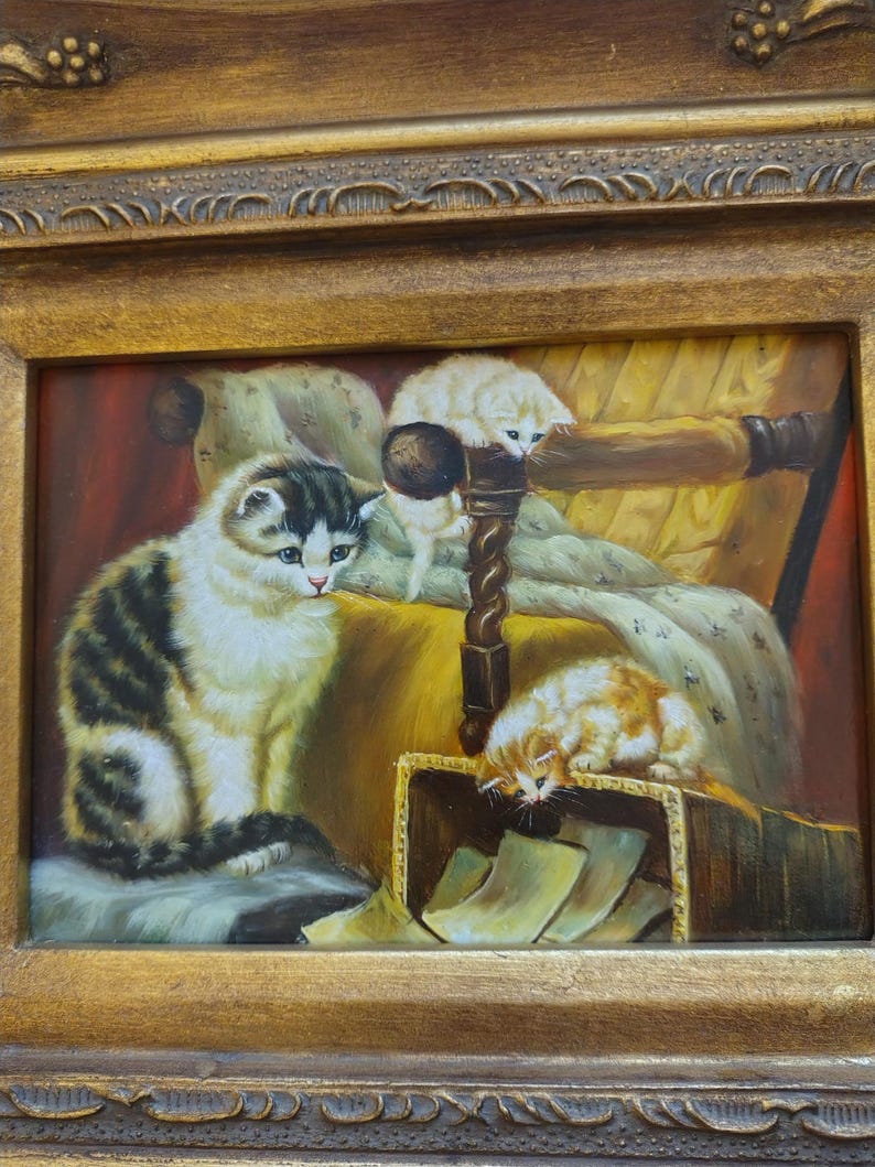 May include: A painting of three cats in a room. The largest cat is sitting on a chair with a yellow cushion. A smaller white cat is climbing on the back of the chair. The smallest cat is orange and white and is looking into a box.