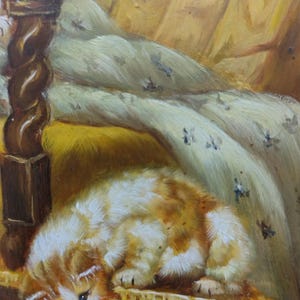 May include: A white and orange kitten with blue eyes is lying on a wooden surface. The kitten is looking down and has its paws tucked under its body. The background is a blurry image of a bed with a white blanket.