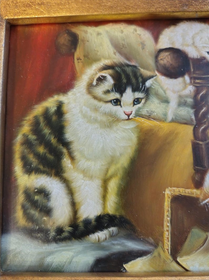 May include: A painting of a white and brown tabby cat sitting on a chair. The cat has blue eyes and is looking to the right. The painting is in a wooden frame.