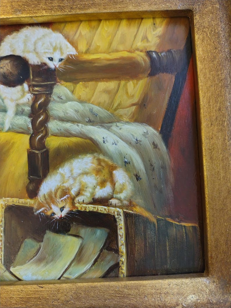 May include: A painting of two kittens in a cozy setting. One kitten is white and is perched on a wooden chair with a yellow cushion. The other kitten is orange and white and is looking into a box filled with papers. The painting has a warm, inviting feel.