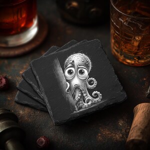 May include: A stack of four black slate coasters. Each coaster features a black and white illustration of a cartoon octopus with large, expressive eyes. The octopus is partially hidden behind a dark object.