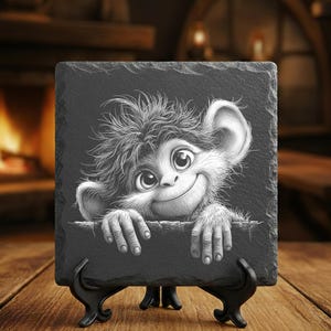 May include: A black slate coaster featuring a whimsical cartoon monkey with large eyes and a friendly smile. The monkey's hands are resting on the edge of the slate. The coaster is displayed on a black stand.