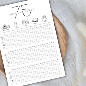 May include: A printable 75 Soft Challenge tracker with a grid of 75 squares. Each square can be marked off with a checkmark or other symbol. The challenge includes five icons: a dumbbell for exercise, a water bottle for hydration, a plate with a fork for healthy eating, a book for reading, and two wine glasses for social time.