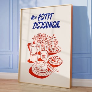 May include: A white poster with a red and blue illustration of a breakfast scene. The text "Mon Petit Dejeuner" is written in blue cursive lettering.