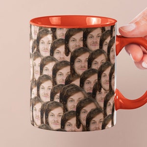 Op de afbeelding: Een rode koffiemok met een witte binnenkant en een handvat. De mok is bedekt met een patroon van een mensen gezicht.