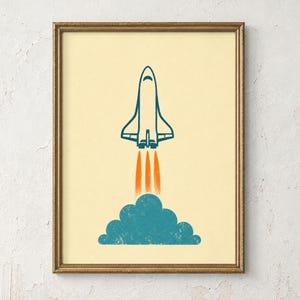 May include: A framed wall art print featuring a stylized teal space shuttle launching upward against a cream background. The shuttle emits three vertical orange exhaust flames above a textured teal cloud of smoke at the bottom of the composition.