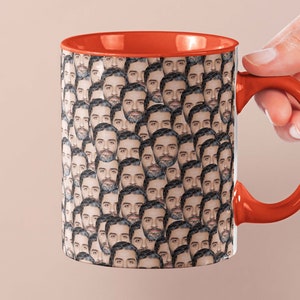 May include: A white ceramic mug with an orange rim and handle. The mug is covered in a pattern of a man's face.