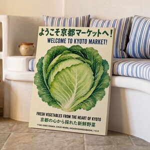 Op de afbeelding: Een rechthoekige poster met een grote, gedetailleerde illustratie van een groene kool in het midden. De tekst luidt: Welcome to Kyoto Market, Fresh Vegetables from the Heart of Kyoto en Japanse karakters. De achtergrond is gebroken wit.