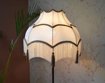 Paralume a conchiglia color avorio: stile vittoriano con finiture e nappe dorate.