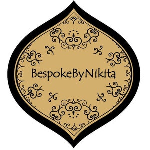 Op de afbeelding: Een gouden en zwart decoratief label met een gestileerd bloemmotief en de tekst "BespokeByNikita".