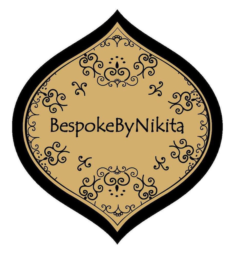 Op de afbeelding: Een gouden en zwart decoratief label met een gestileerd bloemmotief en de tekst "BespokeByNikita".